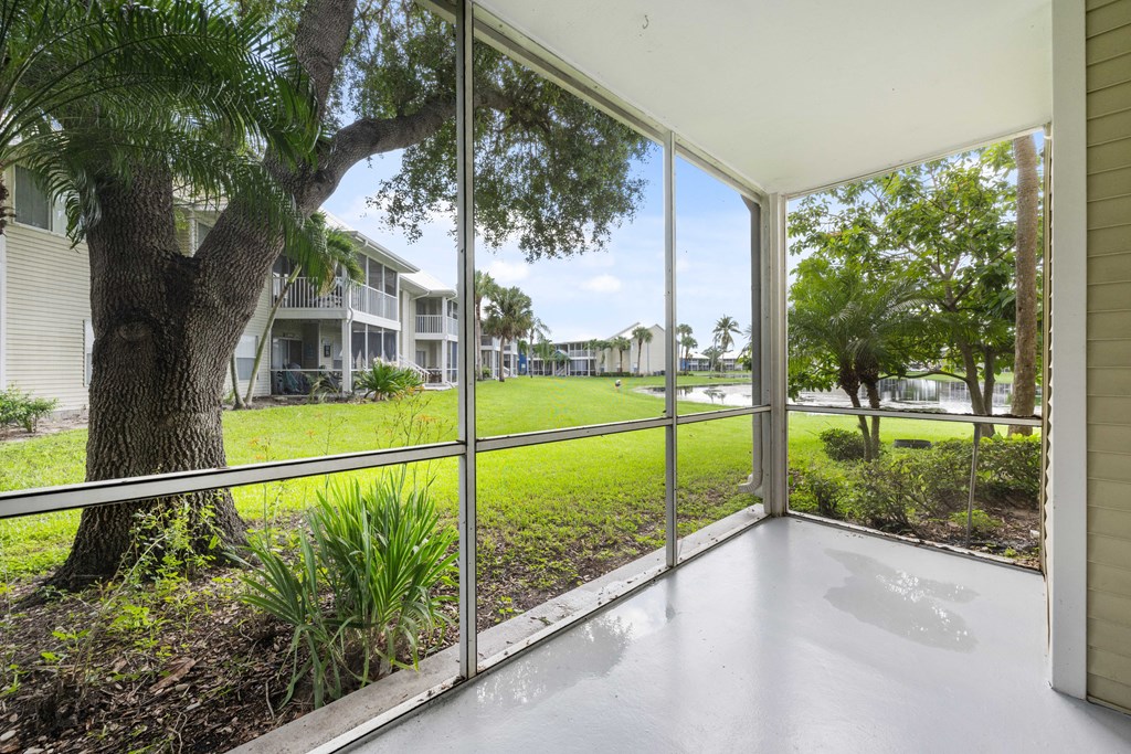 the view from the living room of a house with large windows overlooking a grassy