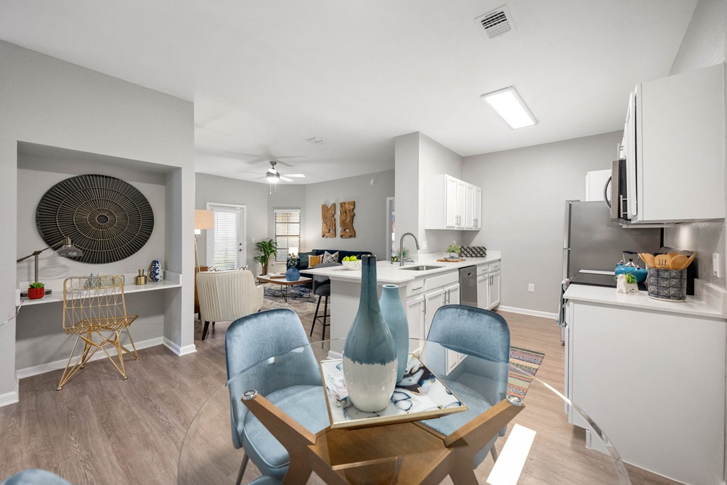an open kitchen and living room with a dining room table and chairs
