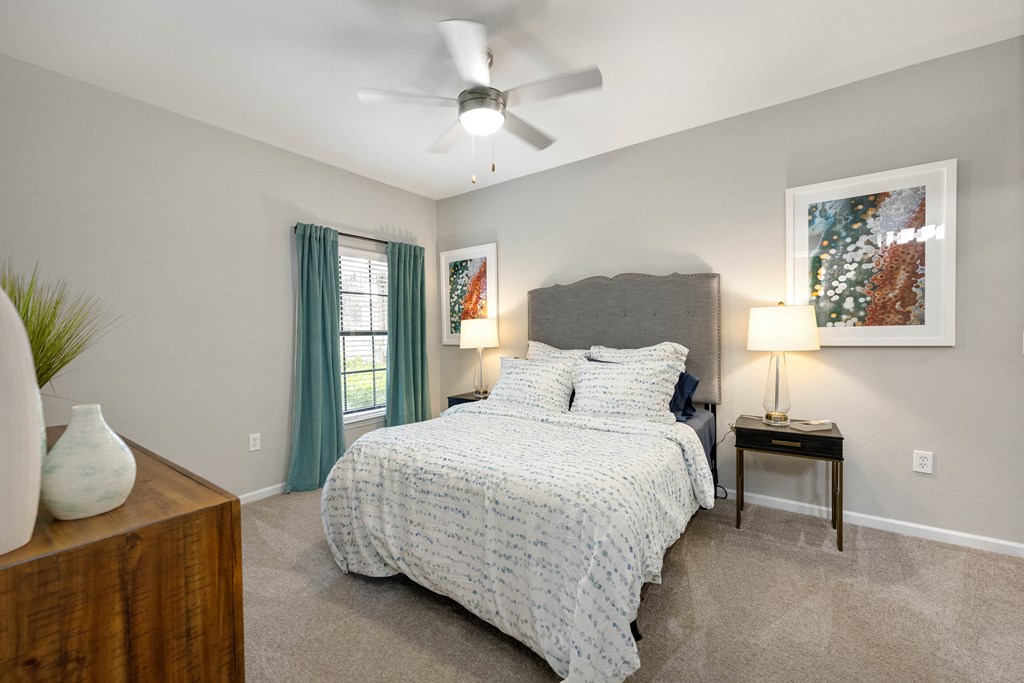 a bedroom with a bed and a ceiling fan