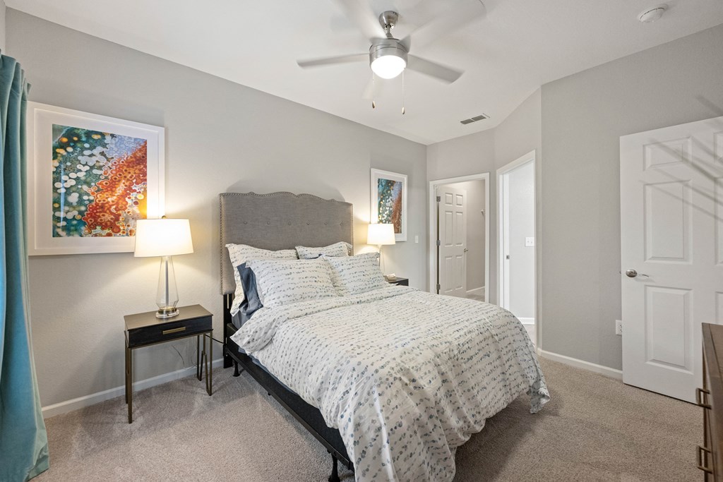 a bedroom with a bed and a ceiling fan