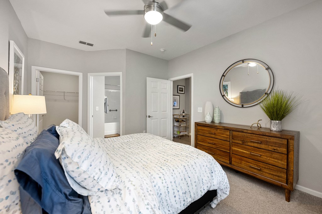 a bedroom with a bed and a dresser and a ceiling fan