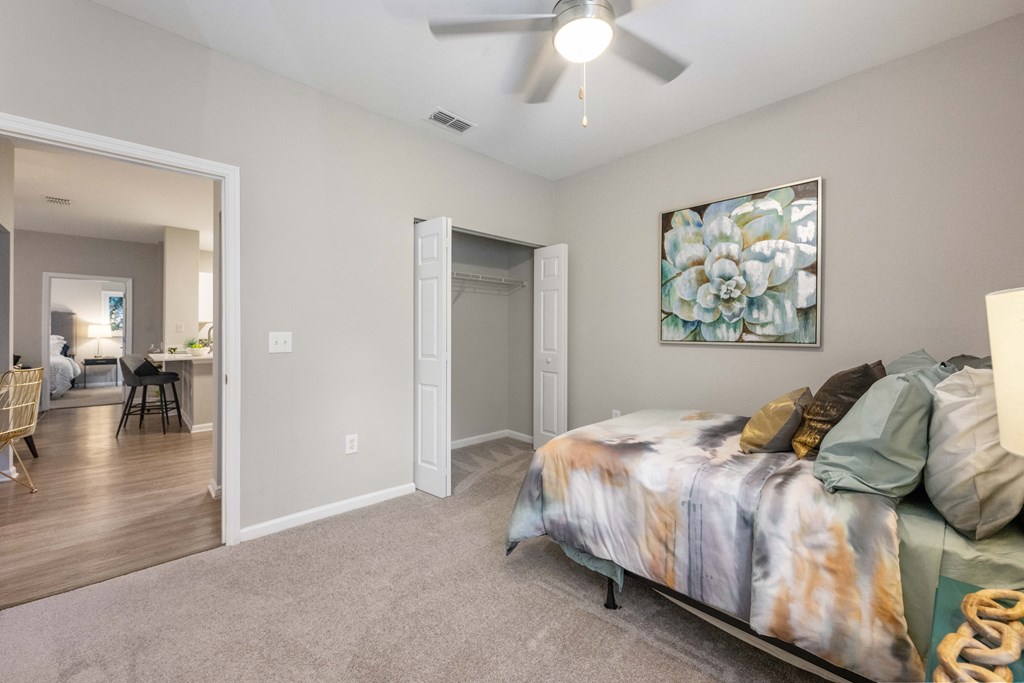 an open bedroom with a bed and a ceiling fan