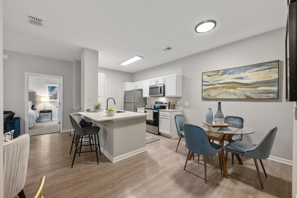 an open kitchen and dining area with a table and chairs and a living room