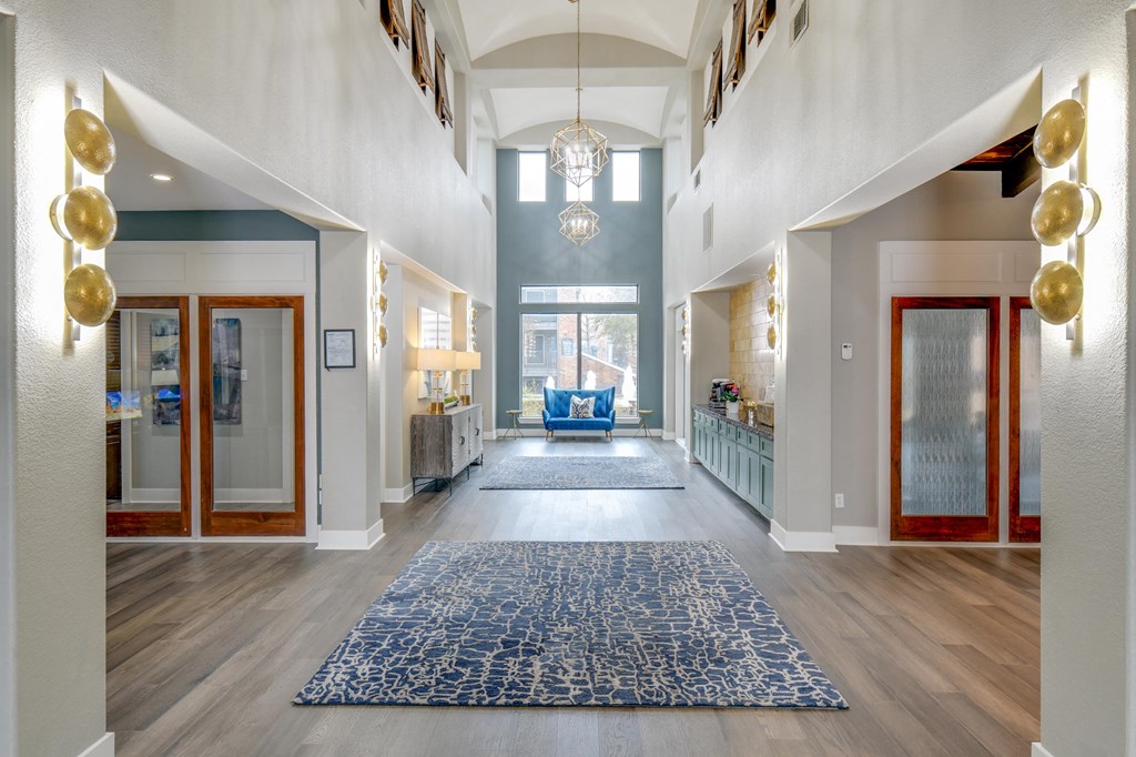 a lobby with a blue rug and a blue couch in the distance