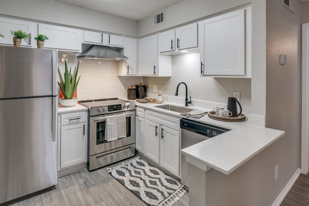 an open kitchen with white cabinets and stainless steel appliances