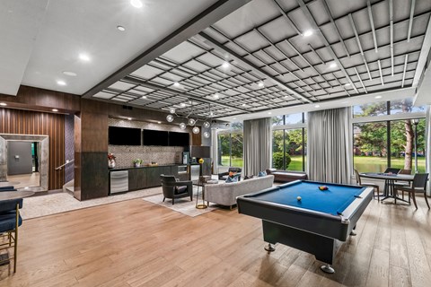 A billiards table is in the middle of a room with a pool table and a bar.