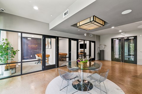 A modern dining room with a glass table and chairs.