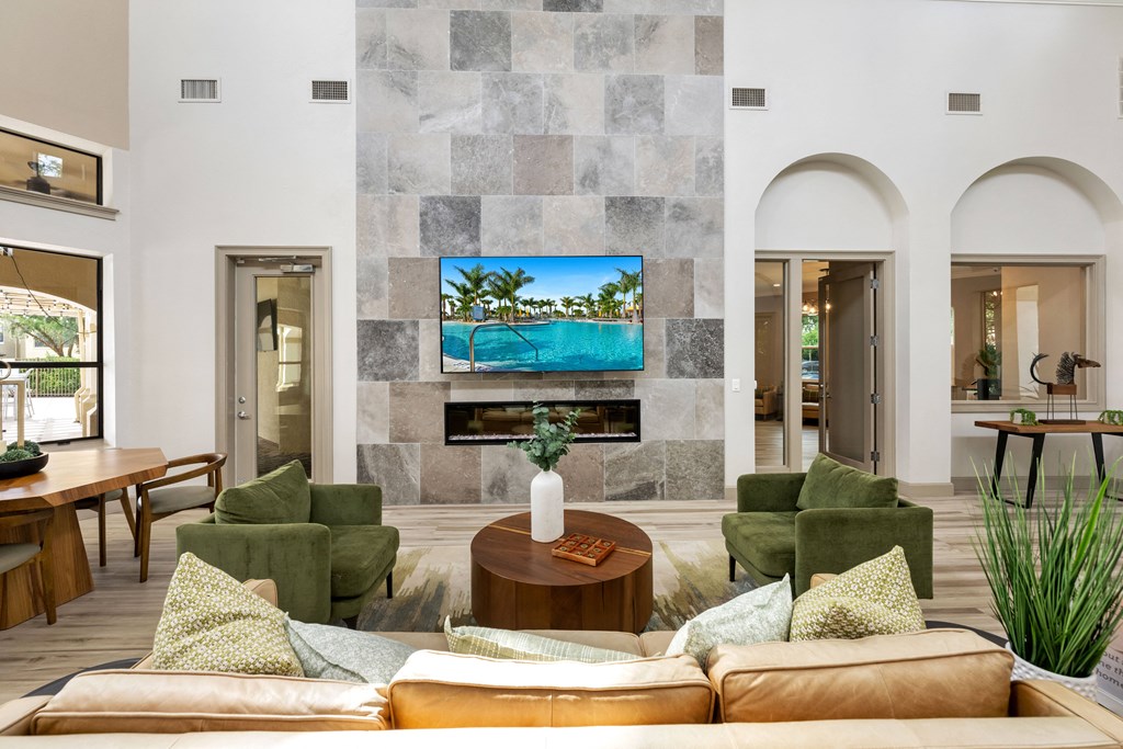 a living room with couches and chairs and a tv on the wall