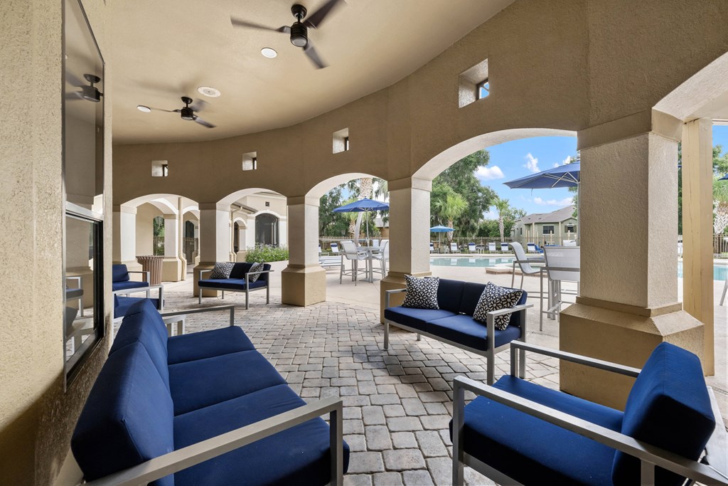 a lounge area with couches and chairs and a pool