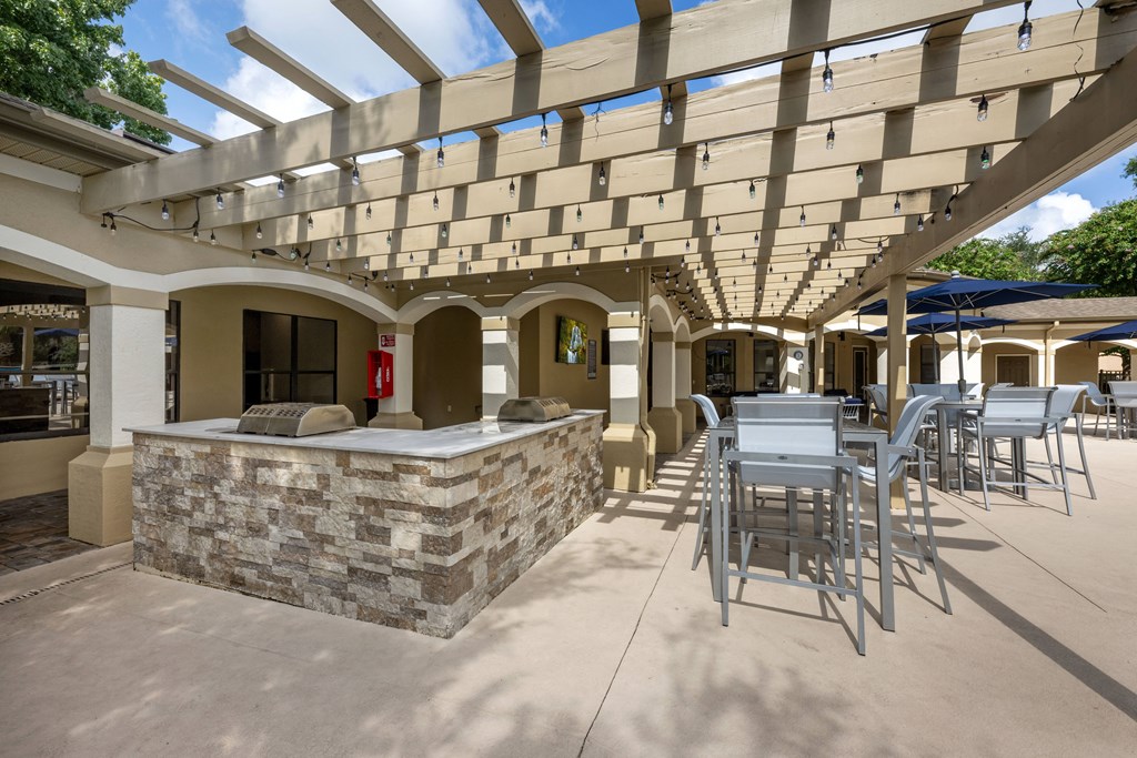 a patio with a bar and tables and chairs