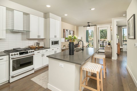A kitchen with white cabinets and a black countertop.