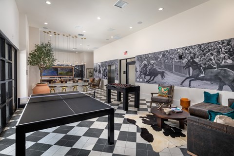 A black and white checkered table is in the middle of a room with a mural on the wall.