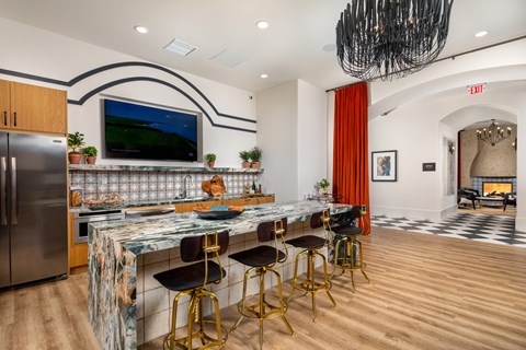 A kitchen with a bar and a television on the wall.