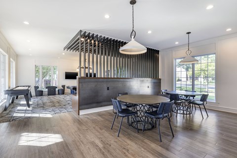 A modern dining room with a large table and chairs.