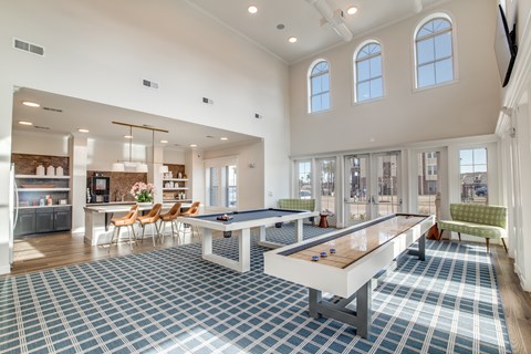 A spacious room with a pool table and a bar area.