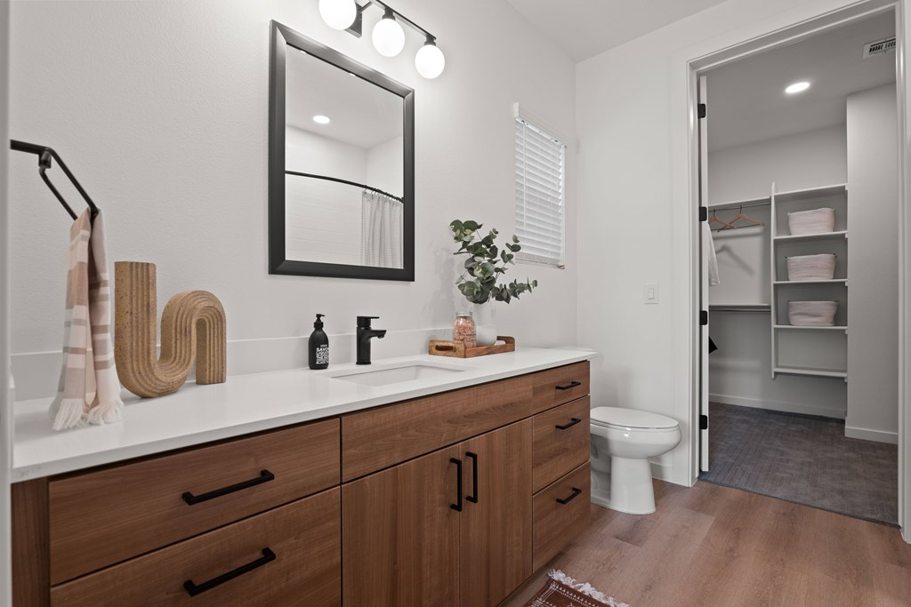 A bathroom with a white countertop and brown cabinets.