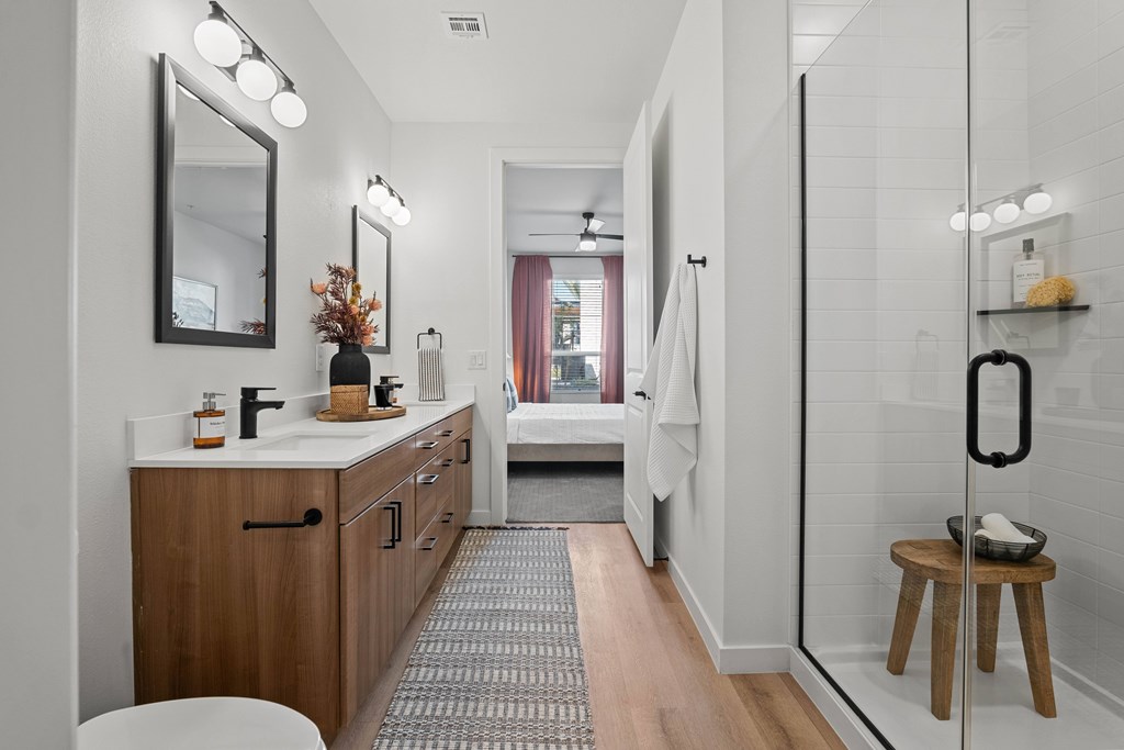 A bathroom with a vanity, mirror, and shower.