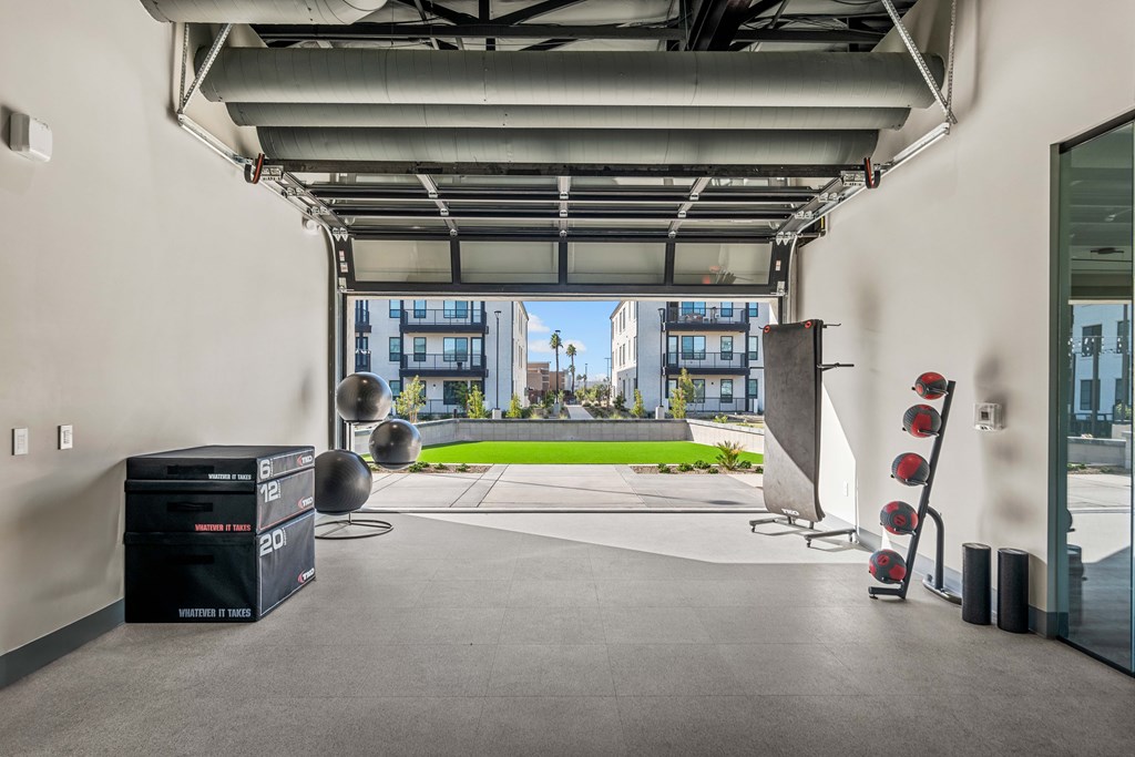 A room with a view of a green outdoor area through a glass wall.