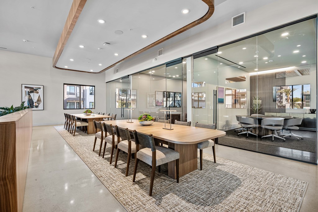 A modern dining room with a long table and chairs.