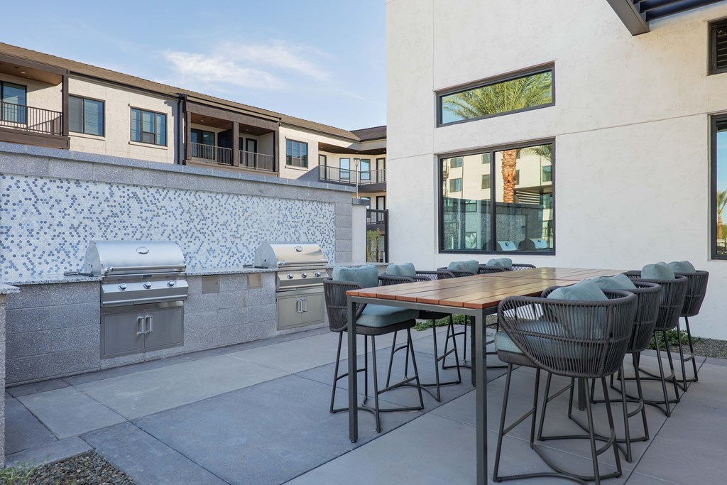 A patio with a table and chairs is set up outside a house.