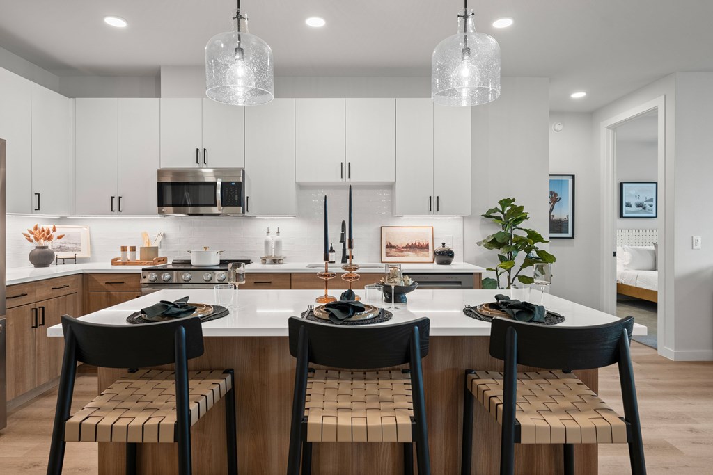A modern kitchen with a center island and bar stools.