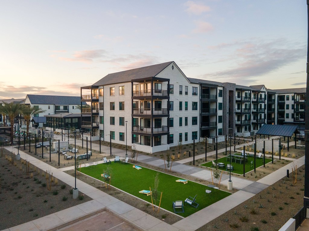 A large white building with a green lawn in front of it.