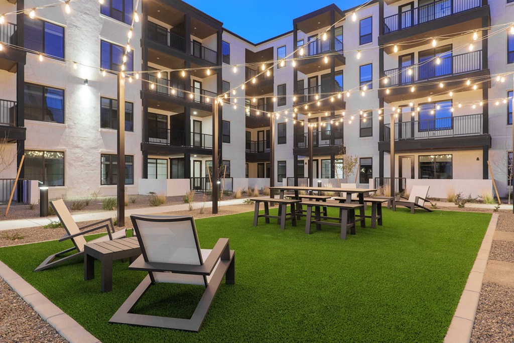 A modern apartment complex with a courtyard and seating area.
