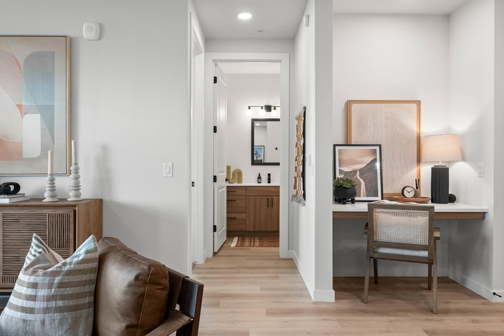 A living room with a brown leather couch and a wooden side table.