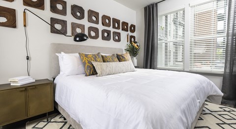 A bedroom with a white bed and a brown cabinet.
