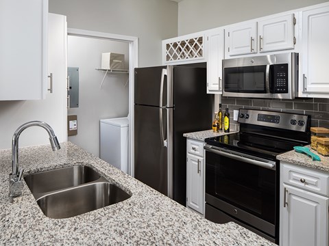 A kitchen with black appliances and granite countertops.at Greys Harbor at Lake Norman, North Carolina
