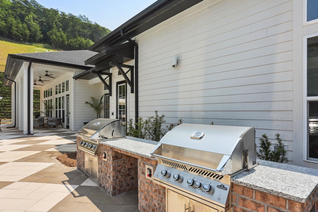 an outdoor kitchen with two bbq grills