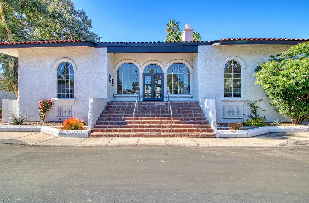 a white building with three doors and three windows