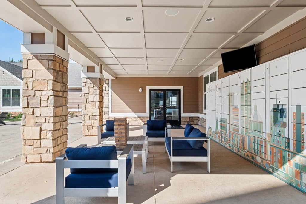 A patio with blue chairs and a stone pillar.