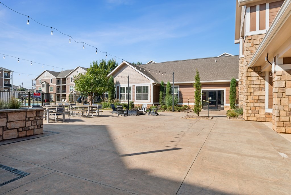 A sunny day at a residential complex with a patio and a building in the background.