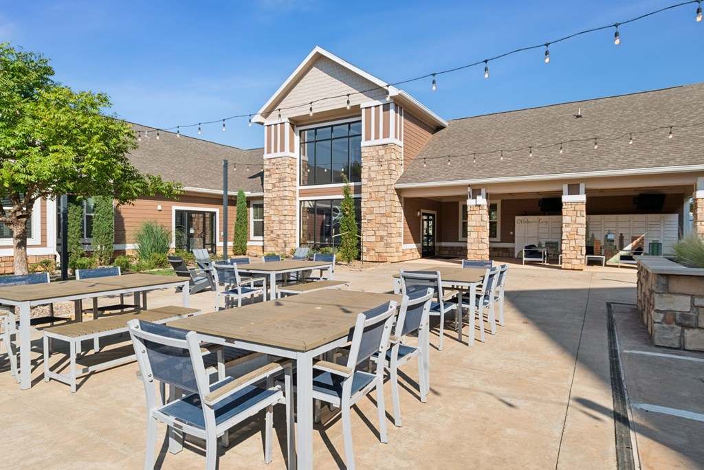 A patio with tables and chairs is set up outside a building.