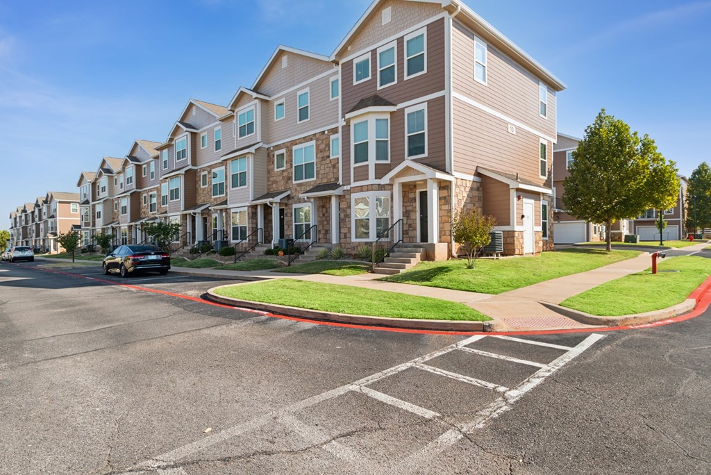 A row of townhouses with a car driving by.