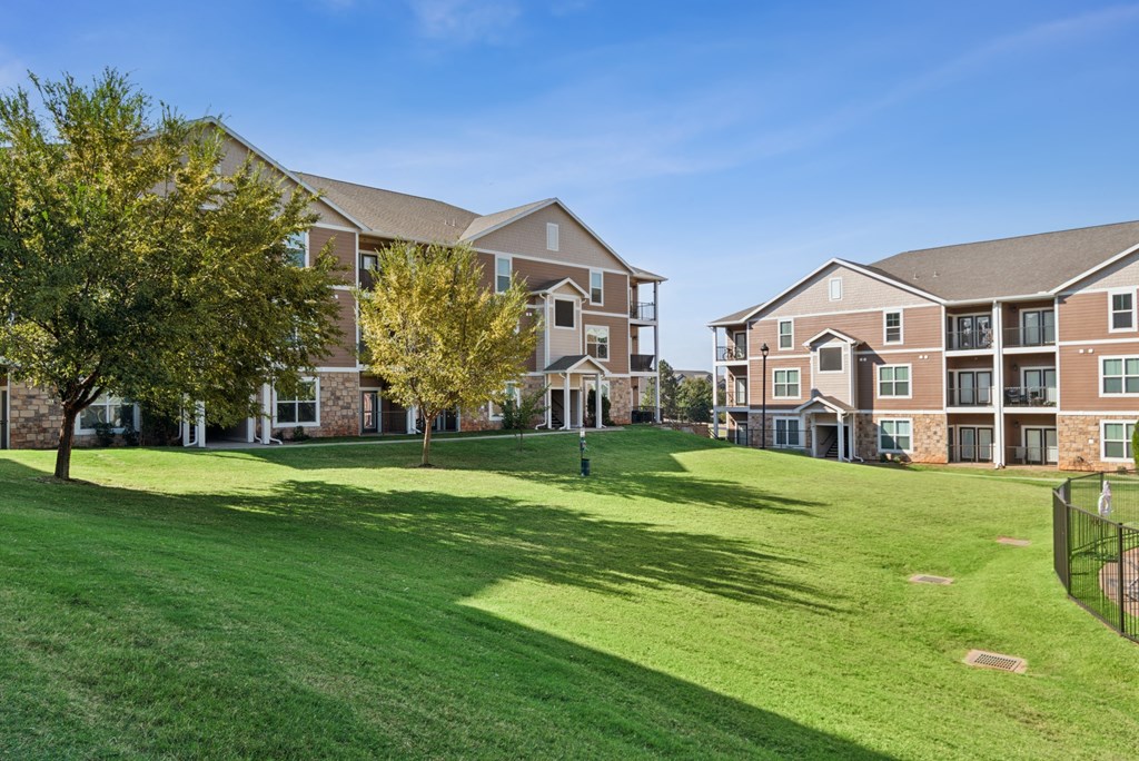 A large grassy area in front of apartment buildings.