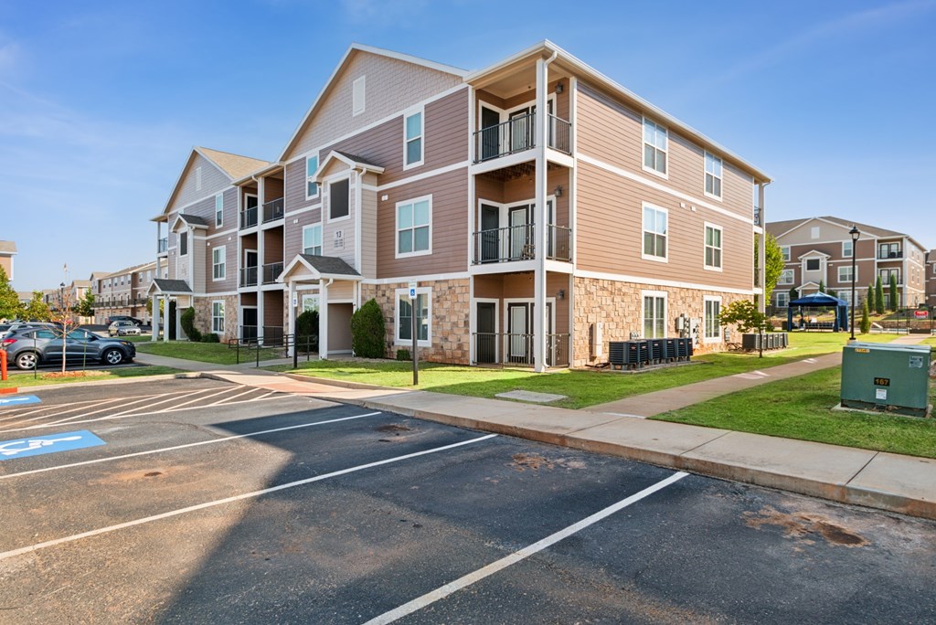 A large apartment building with a parking lot in front.