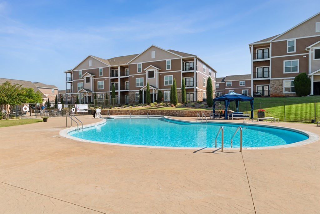 A swimming pool in front of apartment buildings.