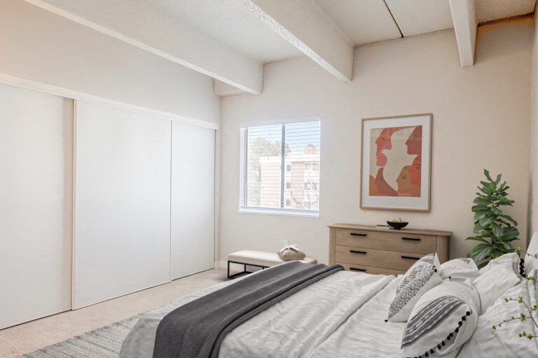 a bedroom with white walls and a bed and a window