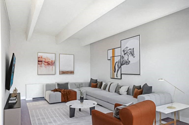 A living room with a grey couch, a coffee table, and a painting on the wall.