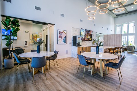 A modern dining room with a white table and blue chairs.