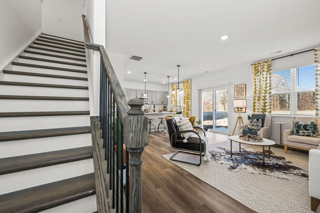 A living room with a staircase on the left side.