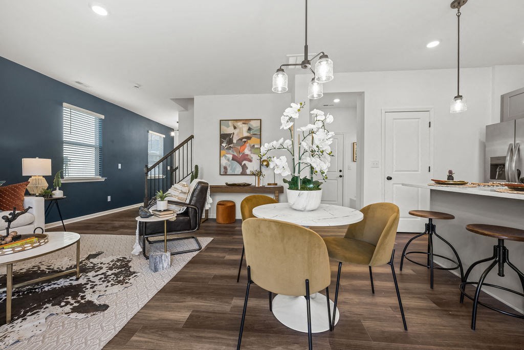 A modern living room with a dining area and kitchen in the background.