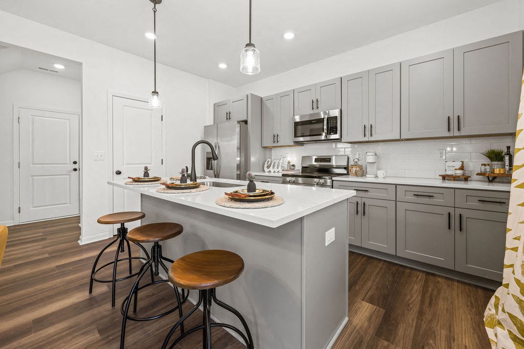 A kitchen with a white countertop and grey cabinets.