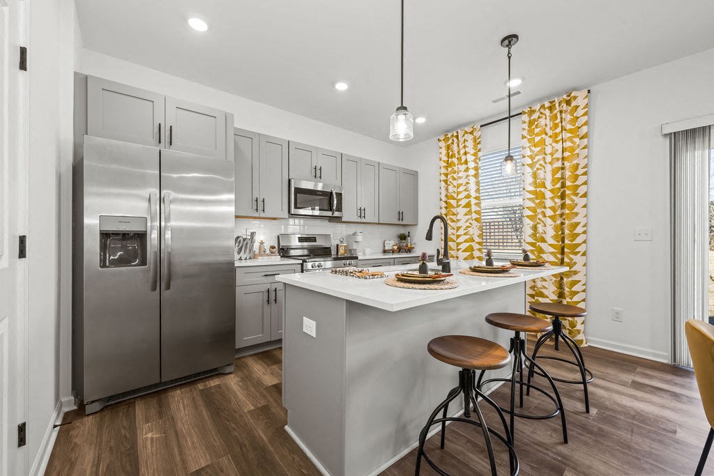 A modern kitchen with a large island and stools.