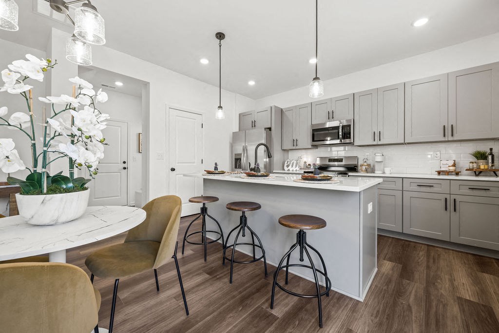 A modern kitchen with a bar area and a dining table.