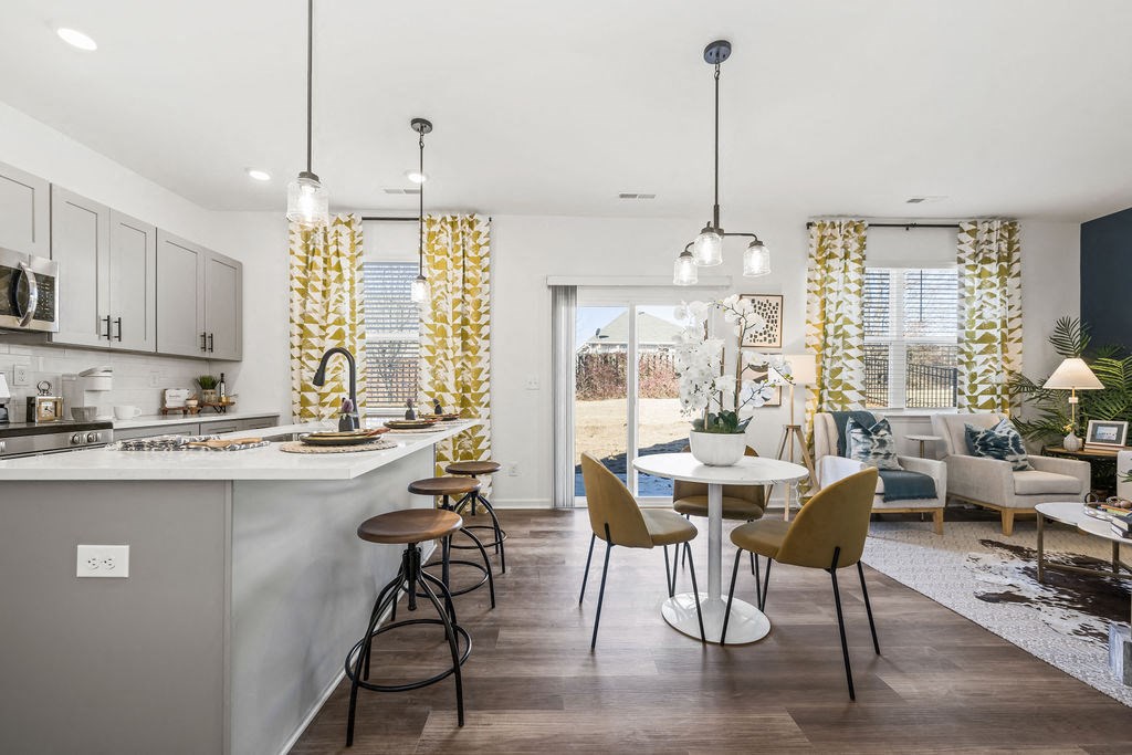 A modern kitchen with a dining area and a living room.