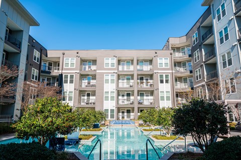 A large apartment complex with a pool in the foreground.