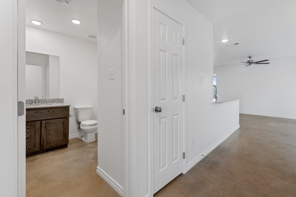 a bathroom with a white door and a toilet and a sink